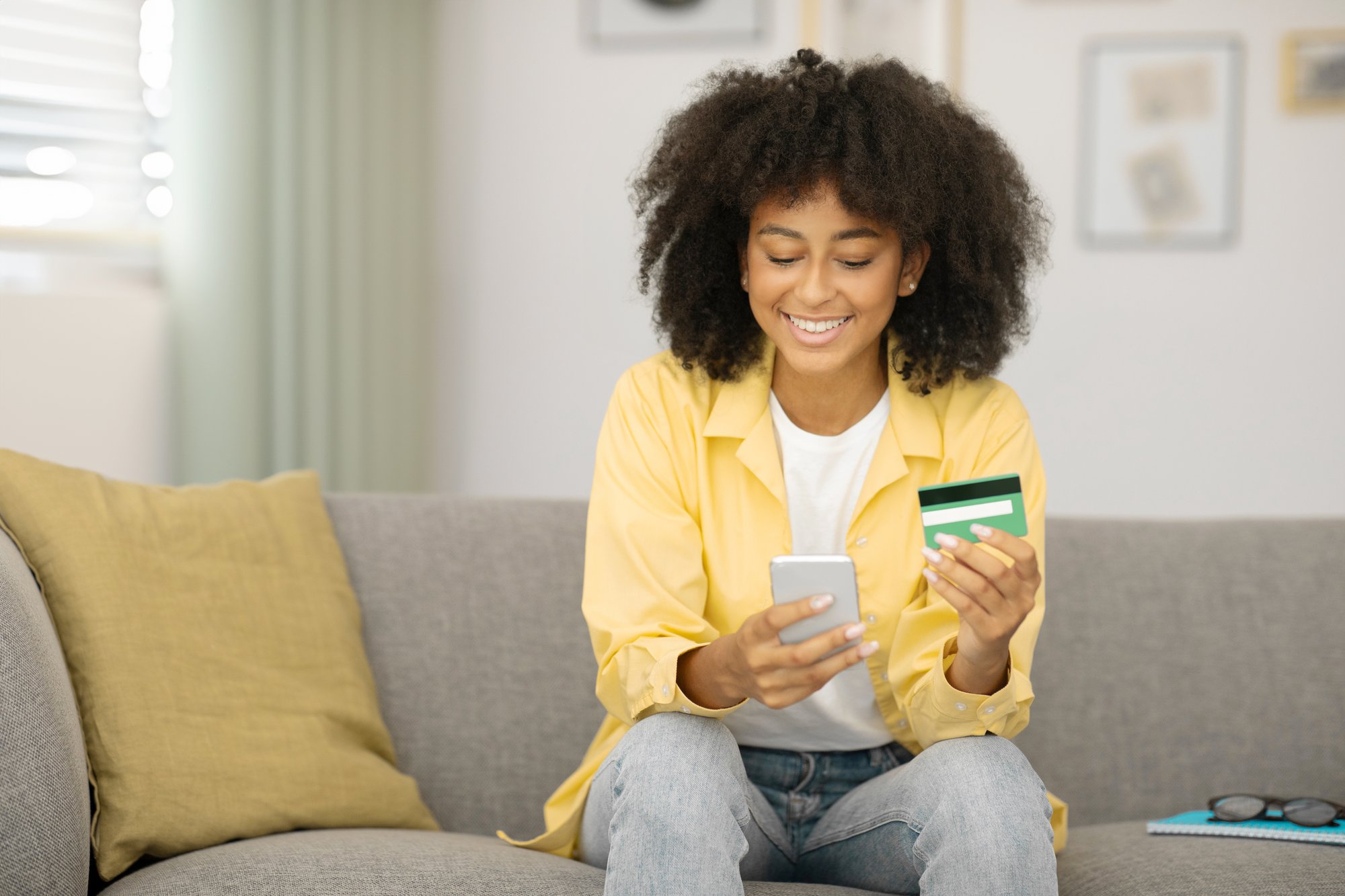 positive-black-lady-shopping-online-with-cellphone-credit-card-making-internet-purchases-from positive-black-lady-shopping-online-with-cellphone-credit-card-making-internet-purchases-from